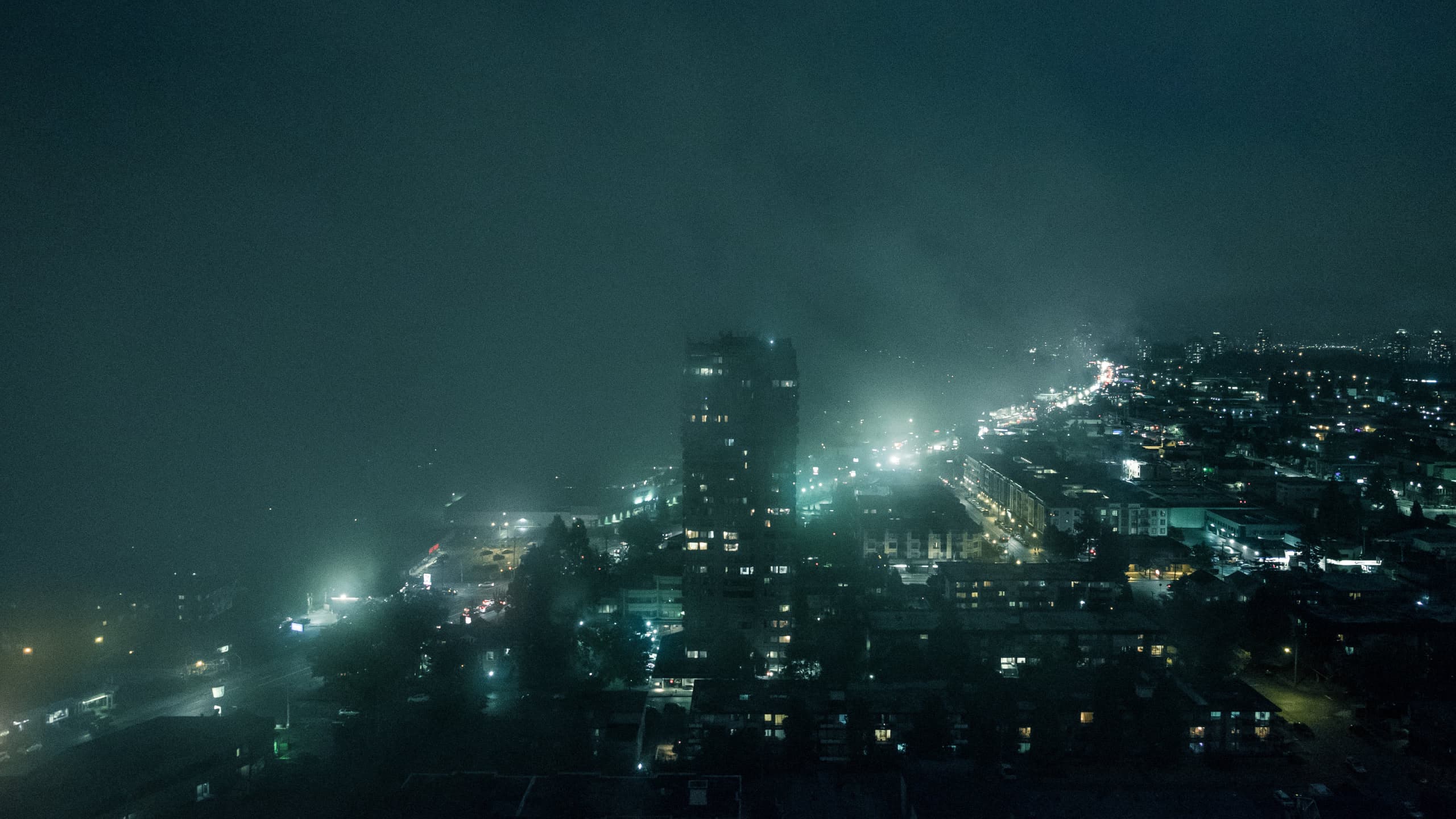City with a dense fog on the left of a major road