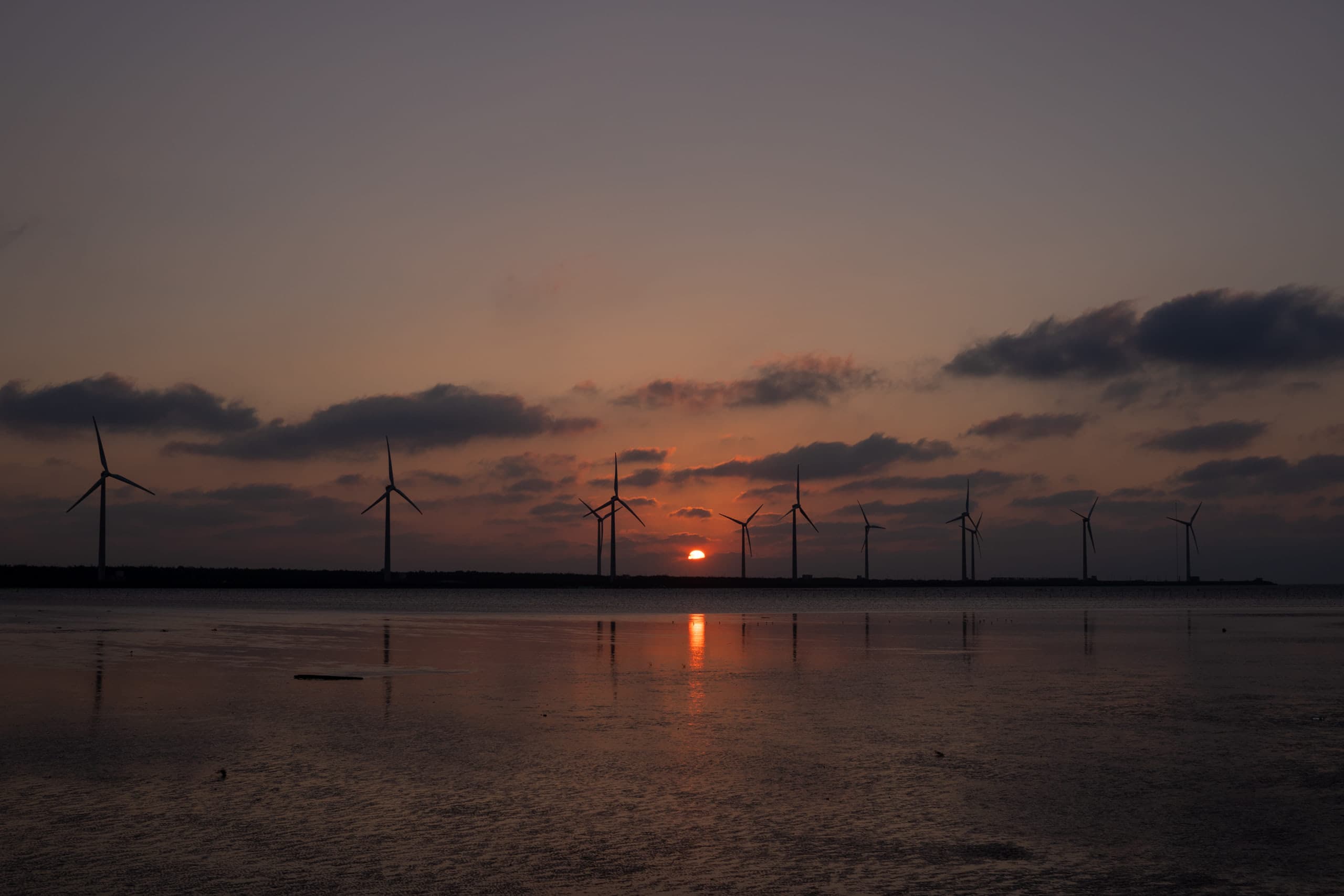 Sunset with a row of windmills at a distance