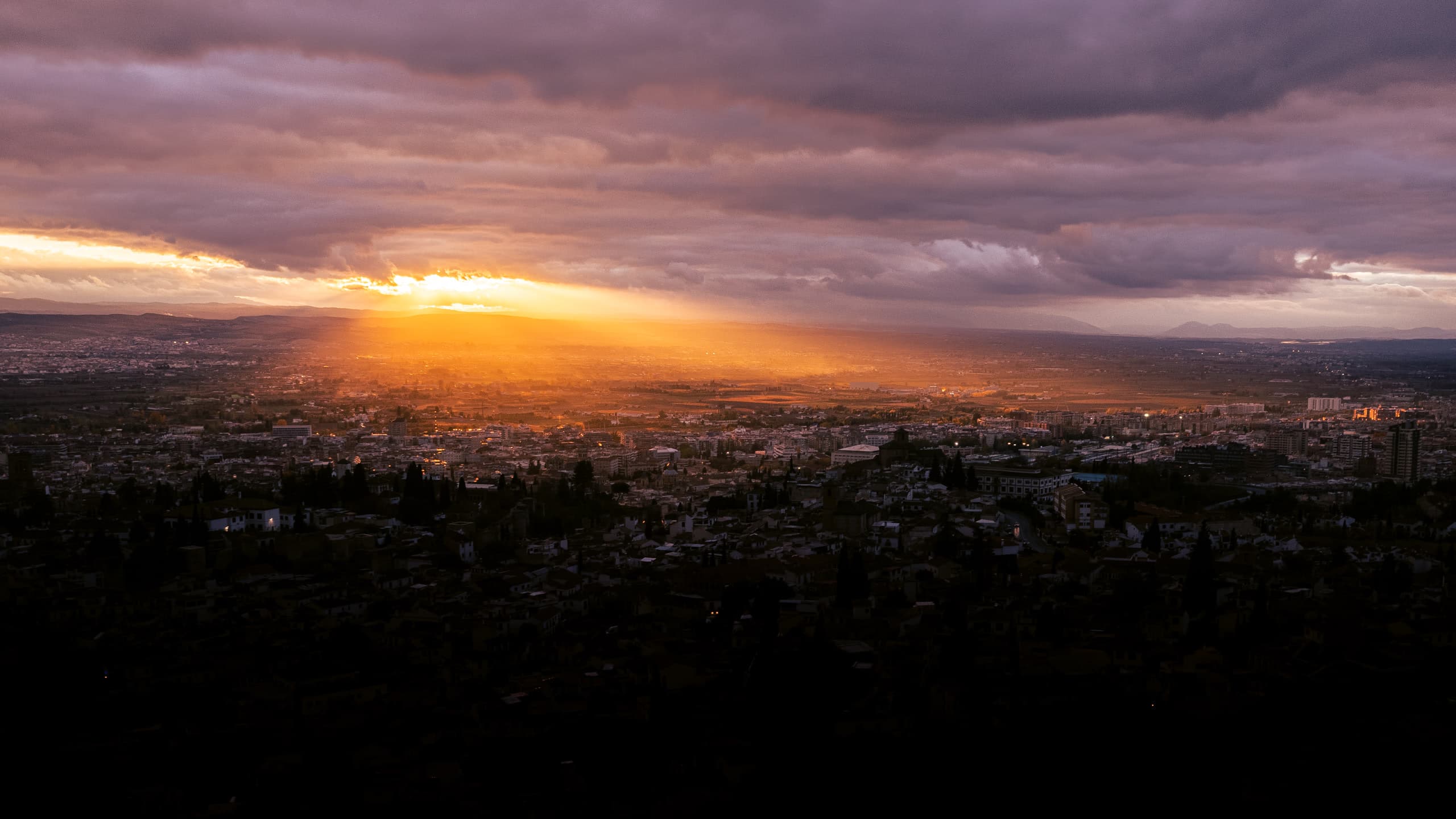 City lit by a flood of sunset light under a cloudy sky