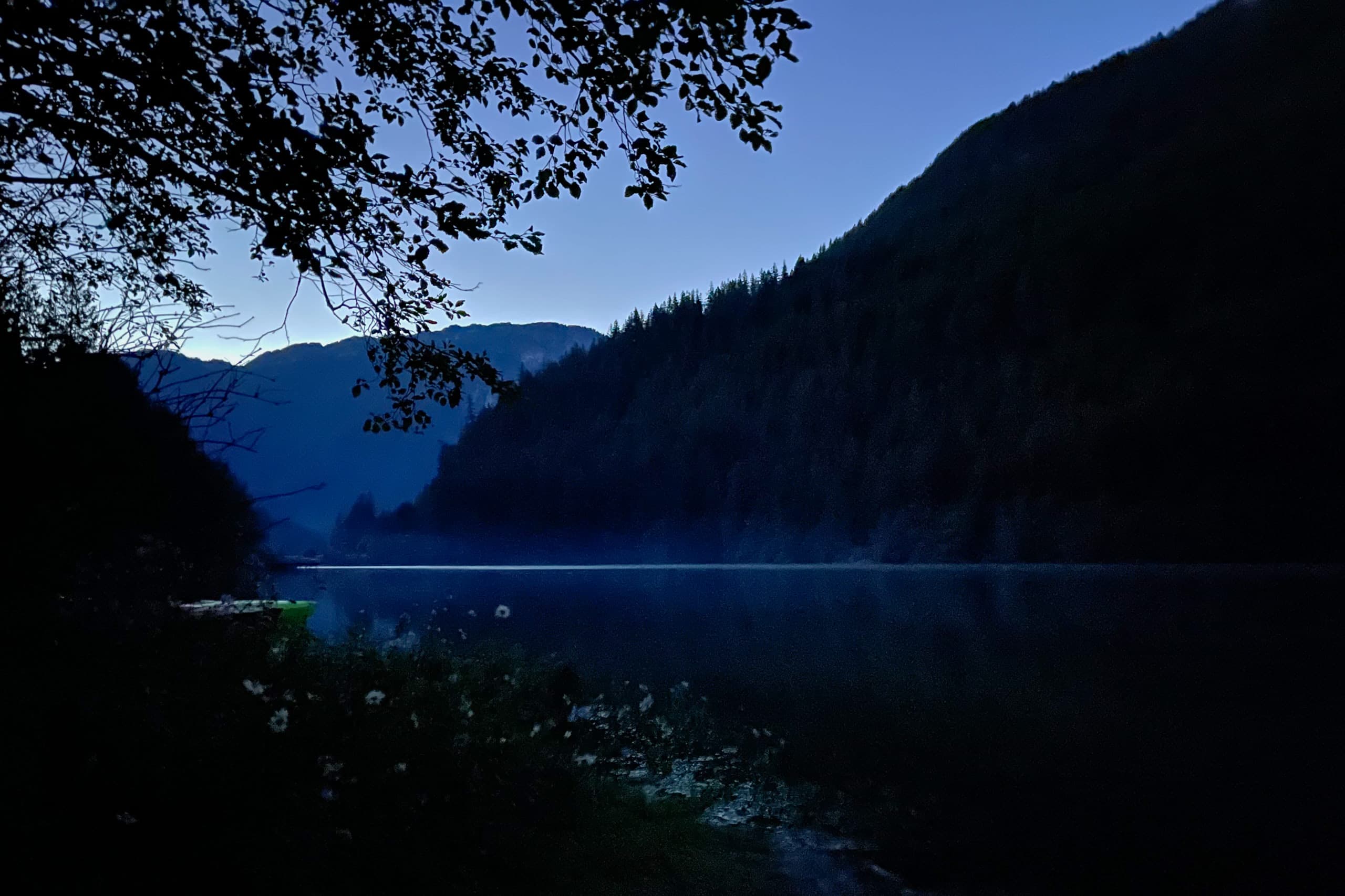 Lake surrounded by mountains with a mist in the distant