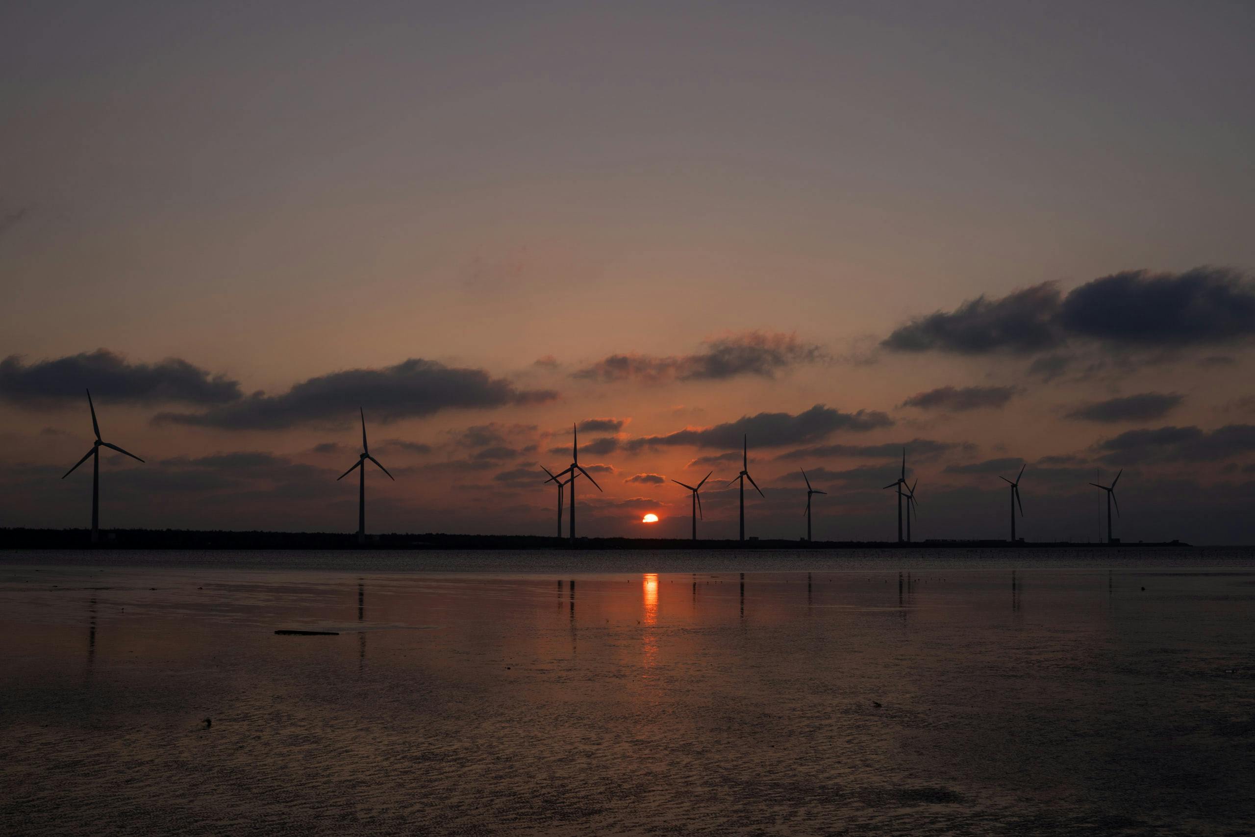Sunset with a row of windmills at a distance