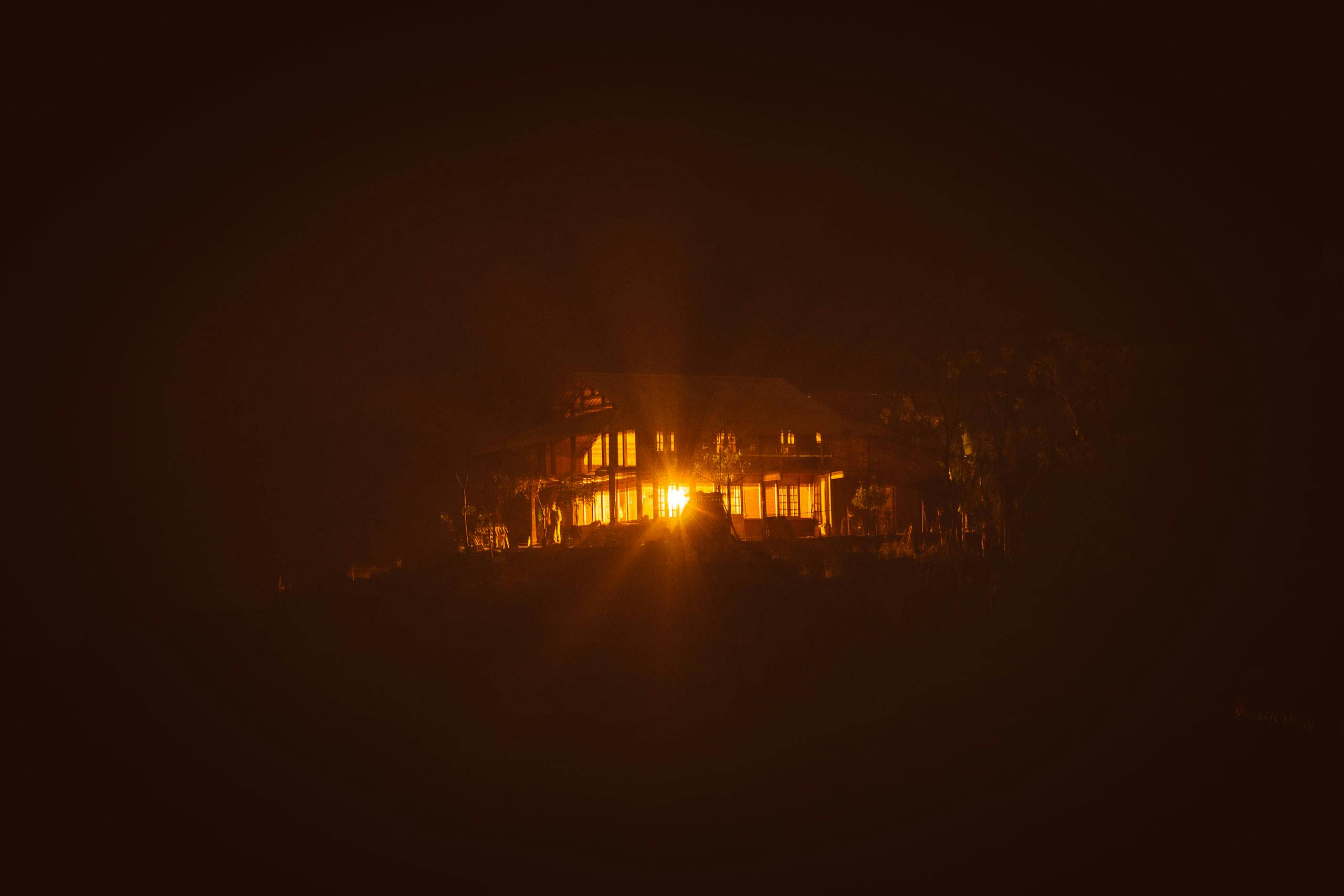 House on a hill with intense light at night