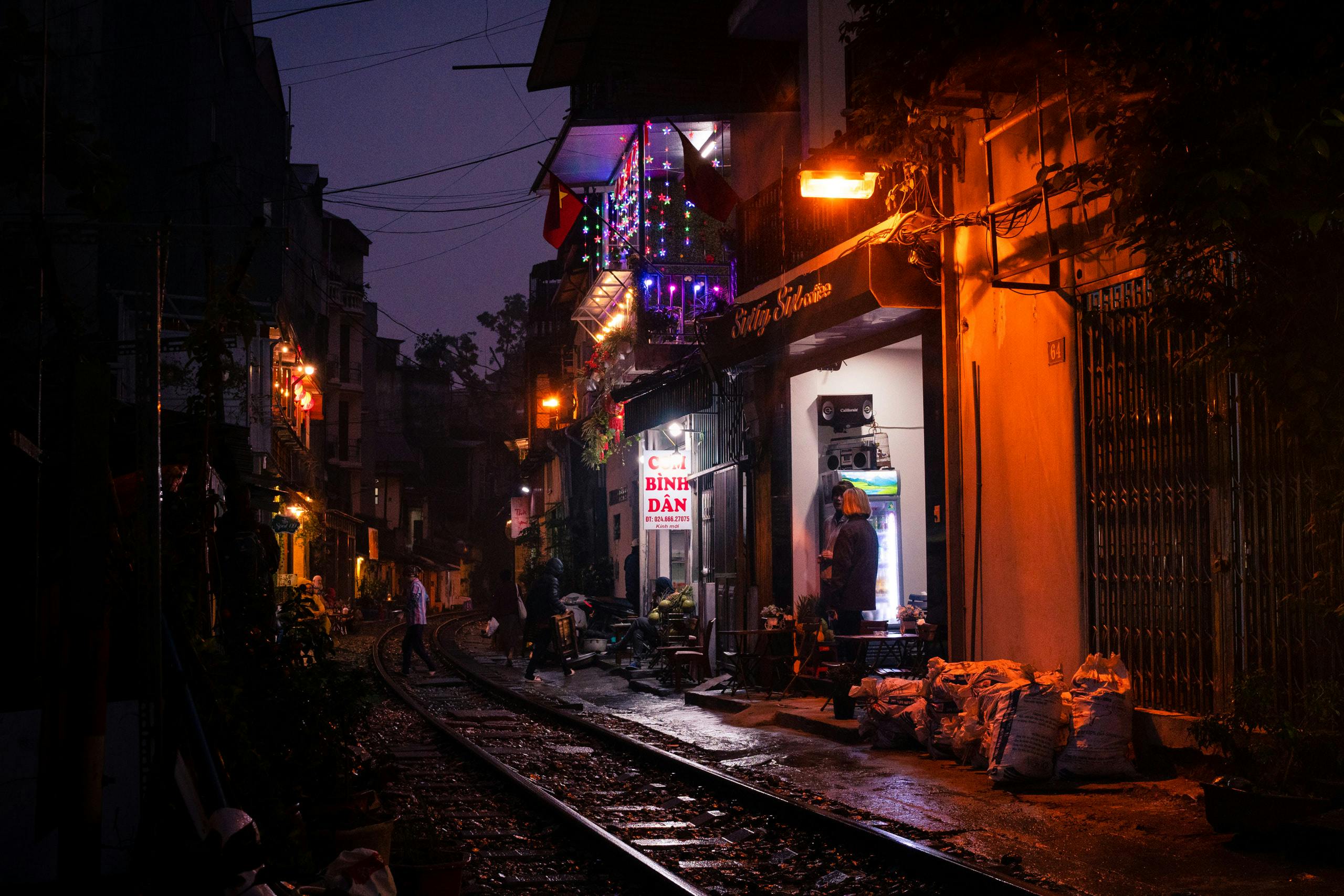 Stores running along an active train track in the evening